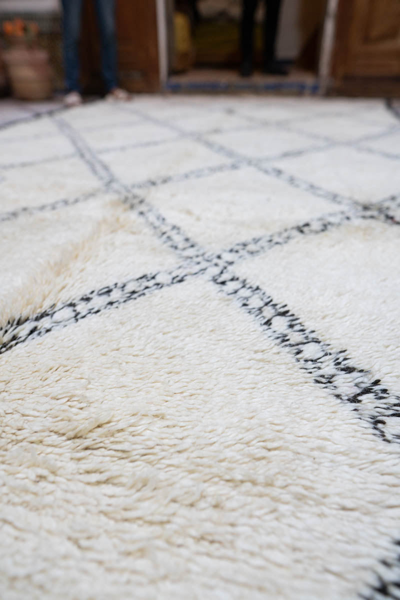 Close-up of a textured white rug with black geometric patterns