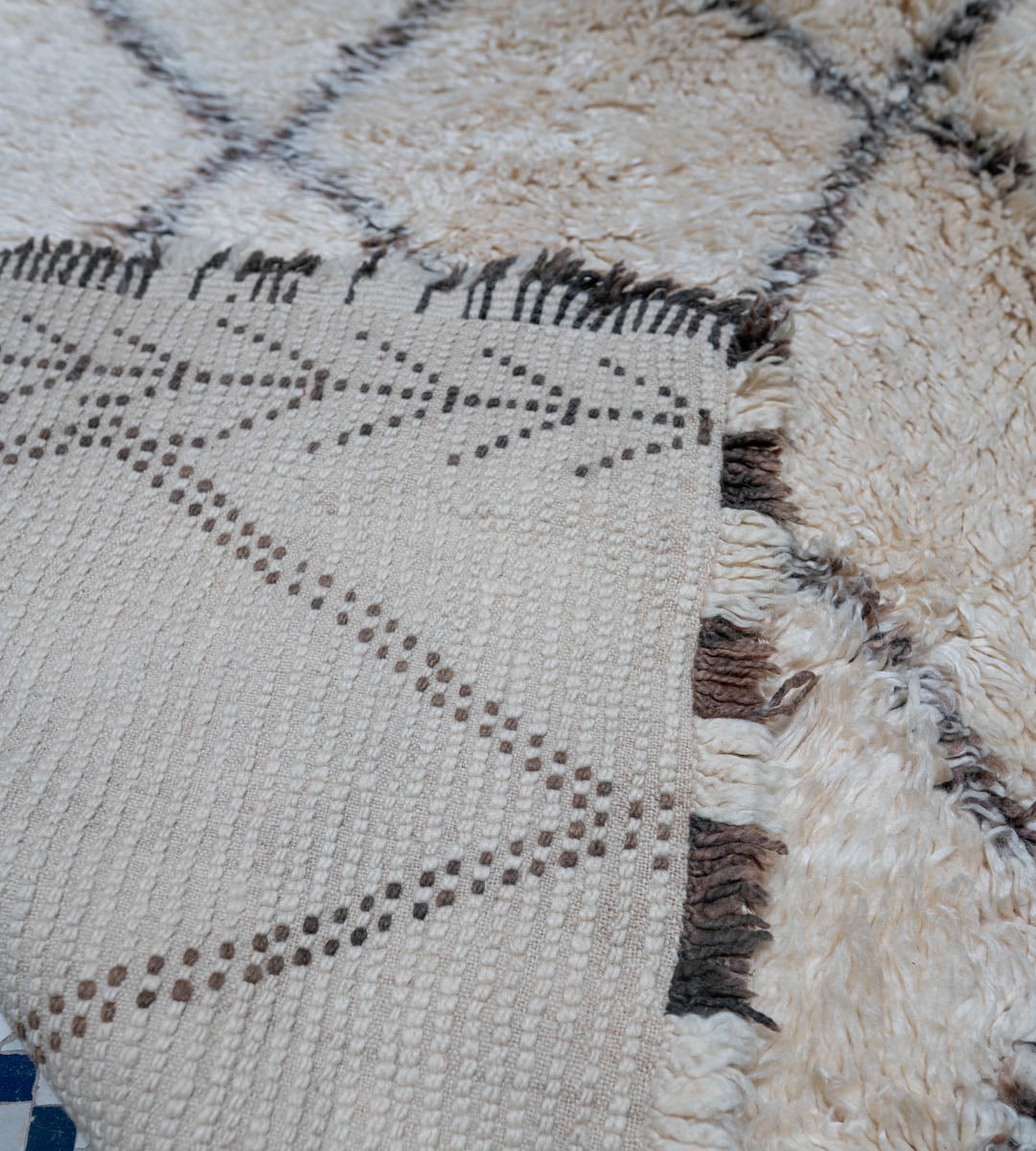 Close-up of a textured fabric with geometric pattern and frayed edge