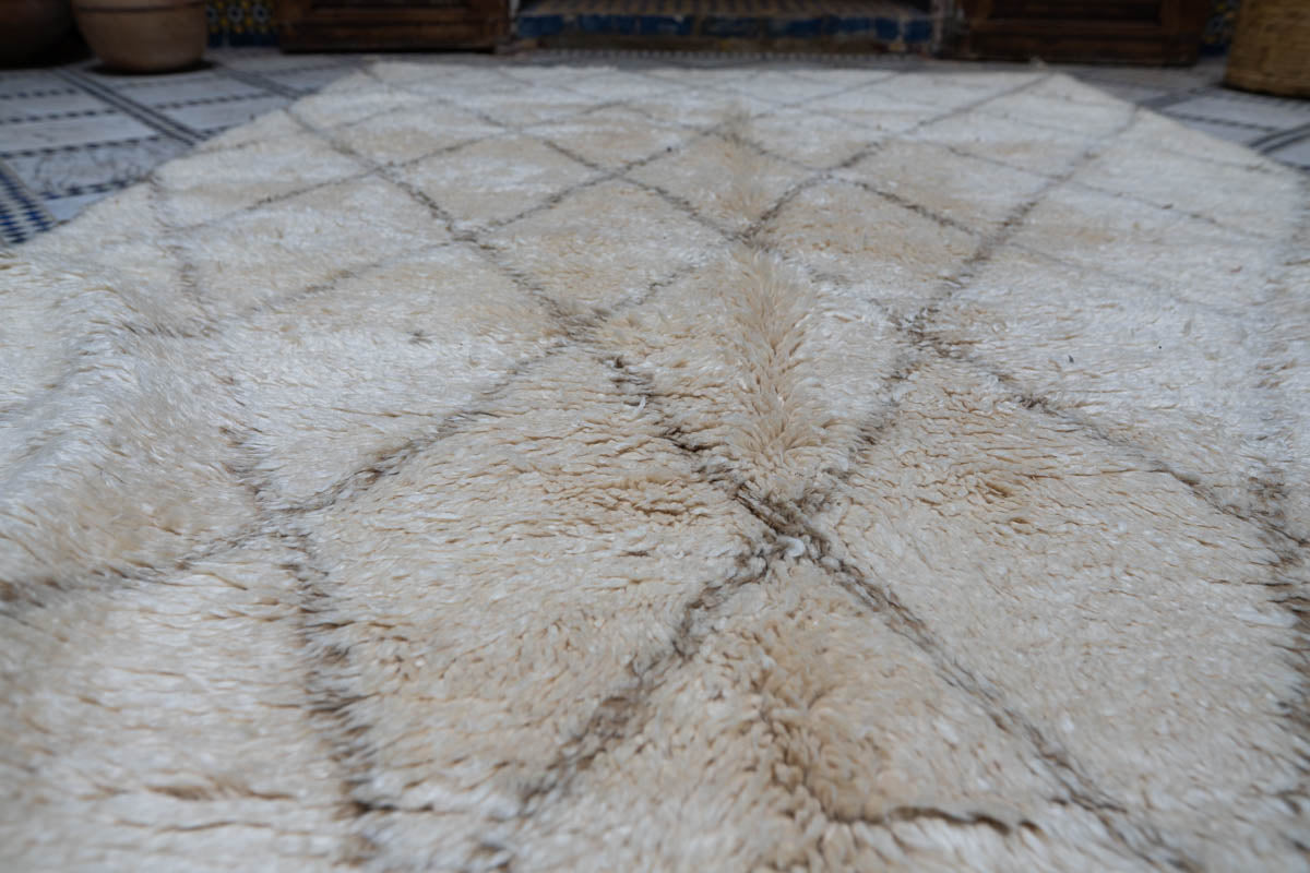 Beige diamond patterned Moroccan vintage rug on a checkered floor