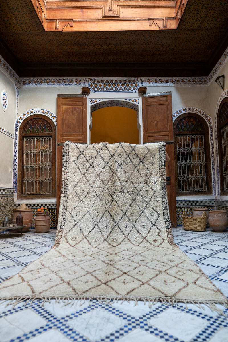 Moroccan-style room with a large Moroccan Beni Ouarain Vintage rug on a checkered floor