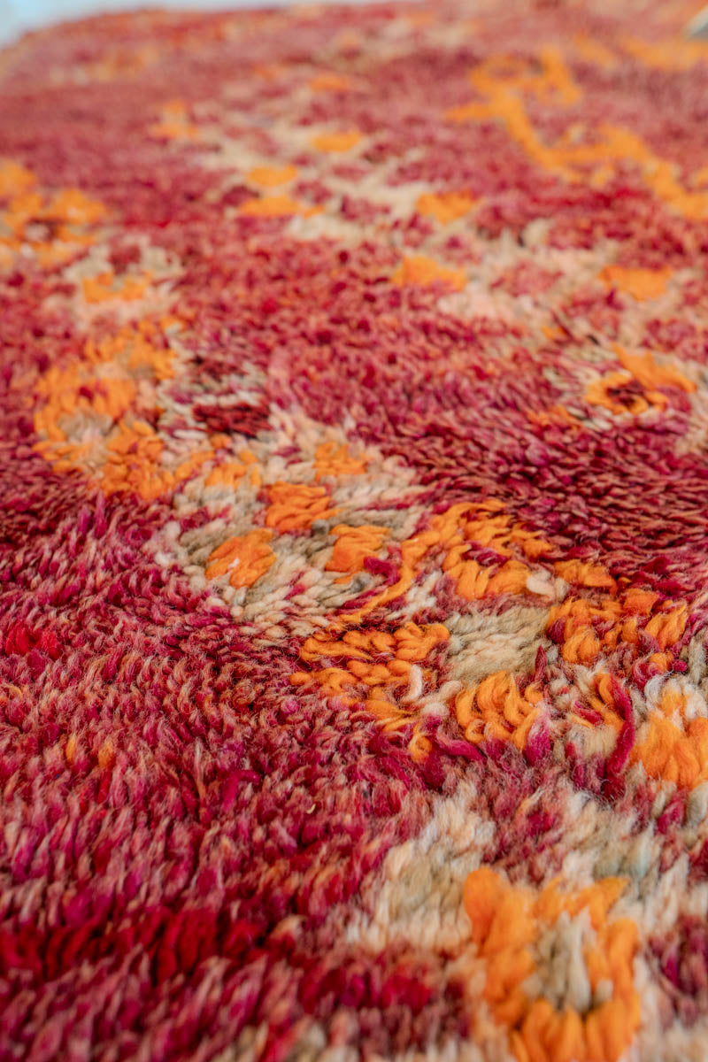 Close-up of a textured red and orange fabric with a pattern